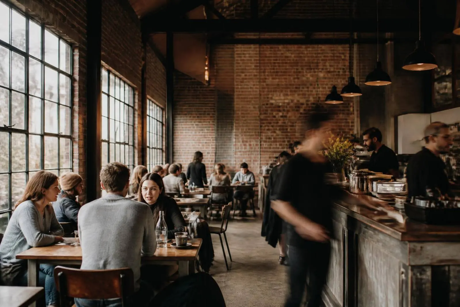 Busy independent cafe in a converted industrial building, the kind of hospitality business Profit Clinic helps make more profitable